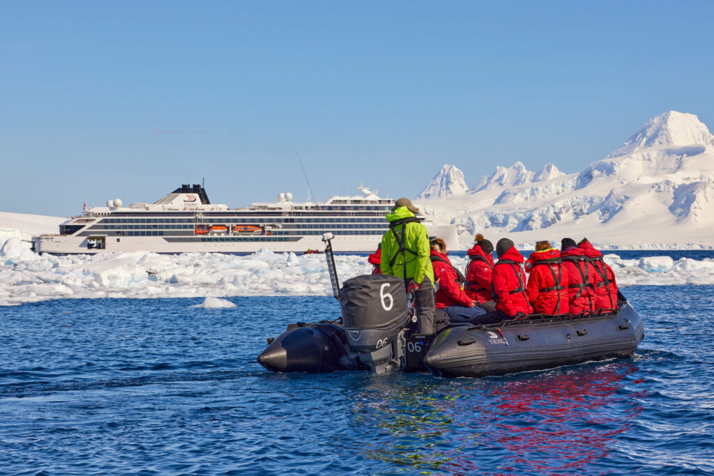 People in red jackets on an inflatable boat in Antactica